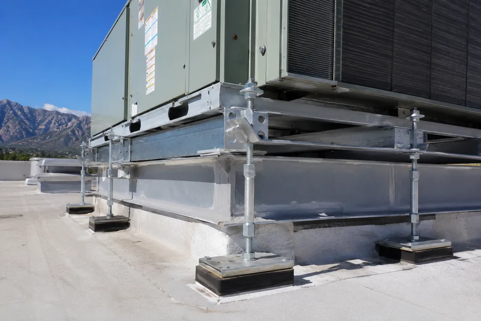 Rooftop HVAC equipment with engineered seismic anchorage — galvanized vibration-isolation curbs, threaded-rod hold-downs, and steel brackets bolted to the structural curb. California PE-stamped per ASCE 7 Chapter 13.