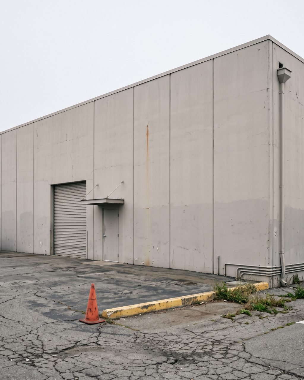 Concrete tilt-up warehouse with full-height wall panels and evenly spaced vertical joints.